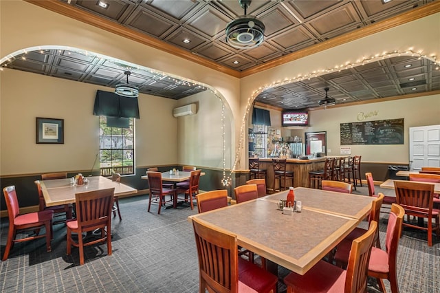 dining space with ceiling fan, carpet floors, and bar area