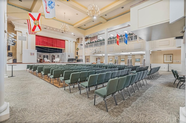 carpeted cinema room featuring a towering ceiling and a notable chandelier