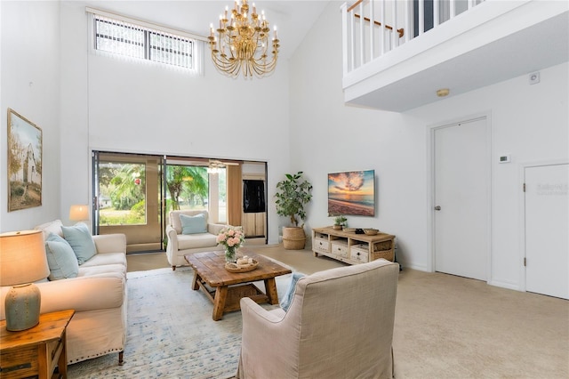 living area with light colored carpet, a notable chandelier, visible vents, and a high ceiling