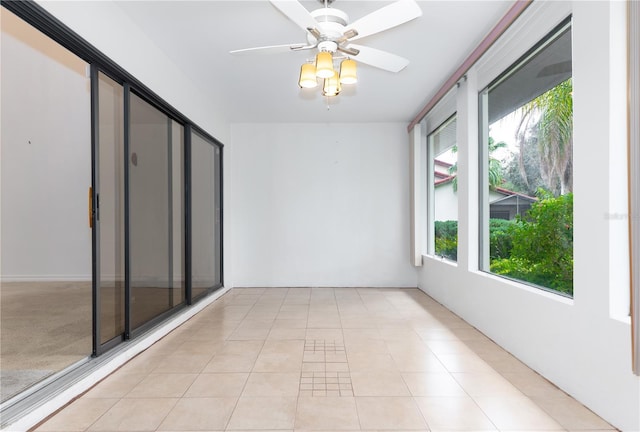 unfurnished sunroom with ceiling fan