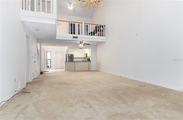 unfurnished living room featuring light colored carpet and high vaulted ceiling