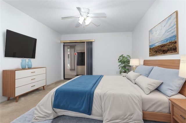 bedroom with ceiling fan, access to outside, a textured ceiling, and light colored carpet