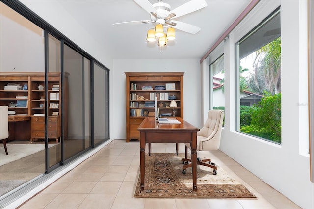 home office with light tile patterned floors and a ceiling fan