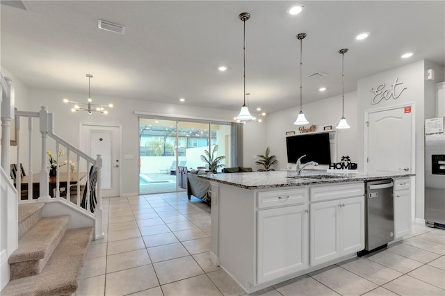 kitchen with light stone counters, sink, light tile patterned floors, white cabinetry, and hanging light fixtures