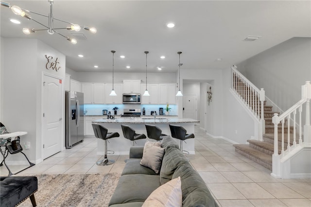 tiled living room featuring a notable chandelier