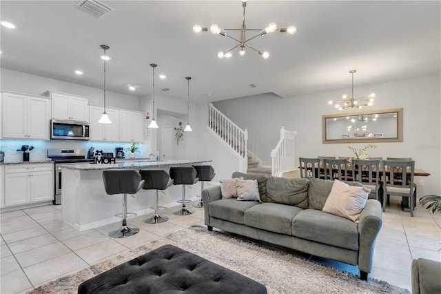 living room with a chandelier, sink, and light tile patterned flooring