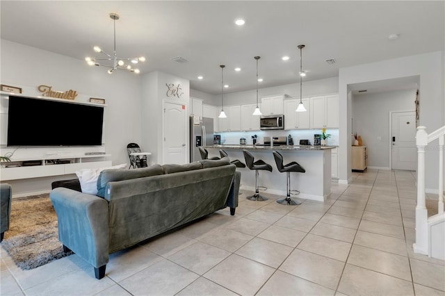 living room featuring an inviting chandelier and light tile patterned flooring