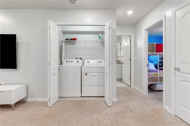 laundry room featuring independent washer and dryer and light colored carpet