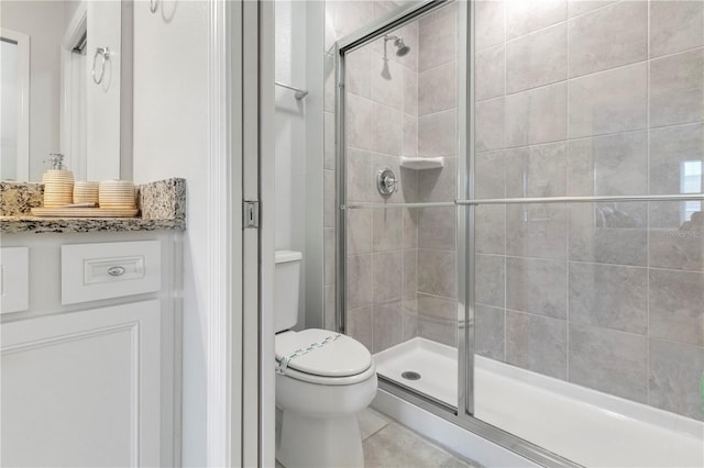 bathroom with tile patterned floors, vanity, toilet, and walk in shower