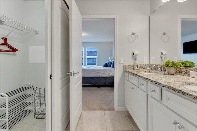 7424 Oakmoss Loop, Davenport, FL 33837 - ensuite bathroom with double vanity and tile patterned flooring