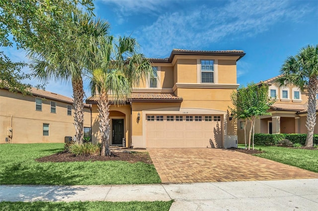 mediterranean / spanish home with a garage and a front lawn