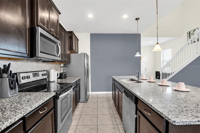 kitchen with pendant lighting, a center island with sink, sink, appliances with stainless steel finishes, and light tile patterned flooring