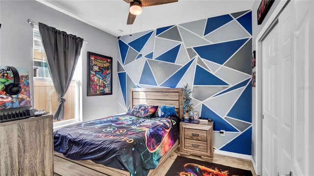 bedroom featuring carpet flooring, ceiling fan, multiple windows, and a closet