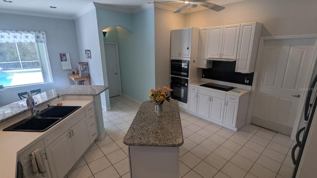 kitchen with sink, white cabinetry, a kitchen island, and black appliances