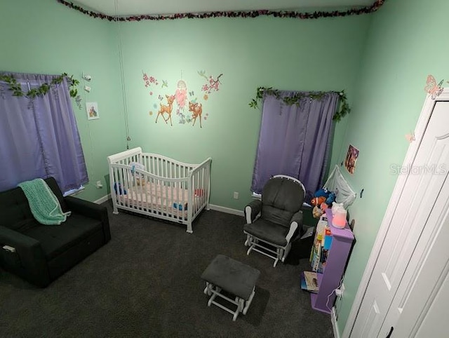 bedroom featuring dark colored carpet and a crib