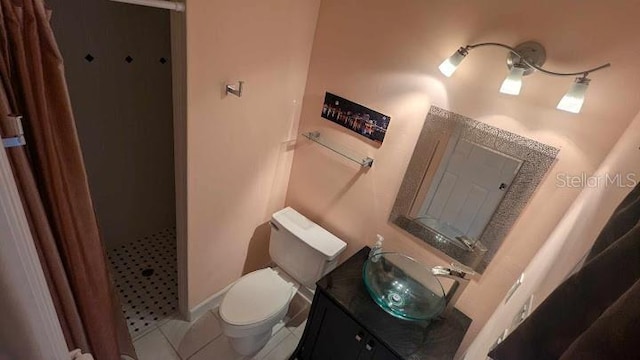 bathroom featuring toilet, a shower, vanity, and tile patterned floors