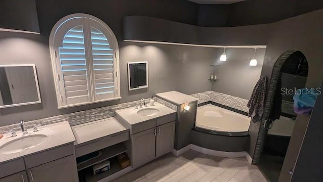 bathroom featuring a washtub and vanity