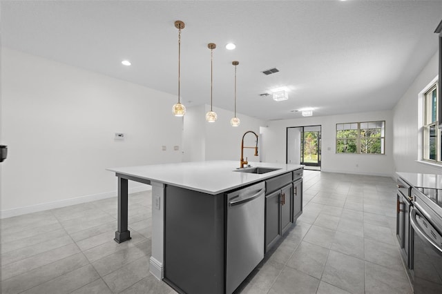 kitchen with a breakfast bar, sink, decorative light fixtures, dishwasher, and an island with sink