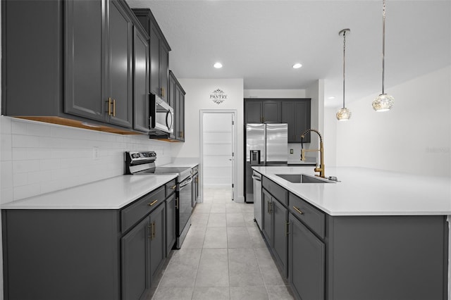 kitchen with appliances with stainless steel finishes, decorative light fixtures, gray cabinets, and sink