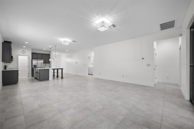 unfurnished living room with washer / dryer