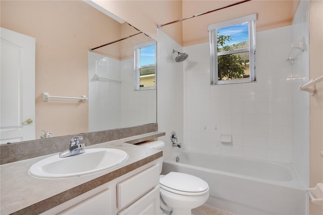 full bathroom featuring tiled shower / bath, vanity, and toilet