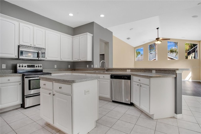 kitchen with kitchen peninsula, ceiling fan, a kitchen island, and appliances with stainless steel finishes