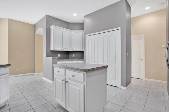 kitchen featuring white cabinets, light tile patterned floors, and a center island