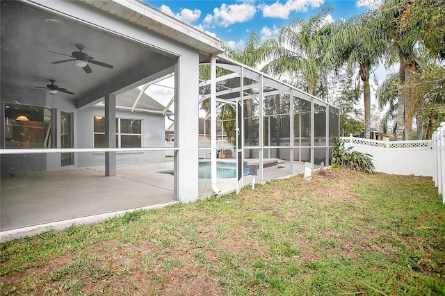 exterior space with glass enclosure, ceiling fan, and a patio area