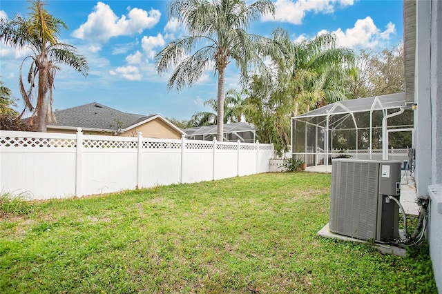 view of yard with a lanai and central air condition unit