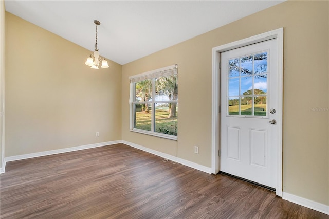 foyer entrance with vaulted ceiling, dark hardwood / wood-style floors, and a notable chandelier