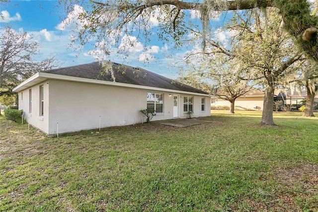 rear view of house with a patio and a lawn