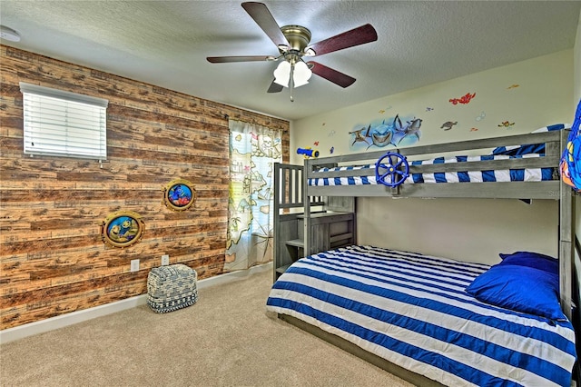 carpeted bedroom featuring a textured ceiling, ceiling fan, and wooden walls