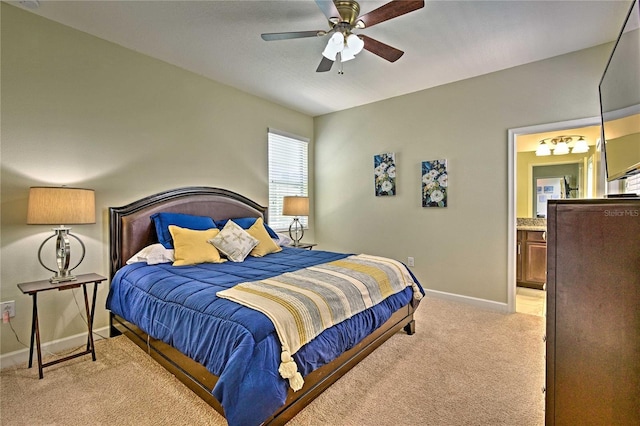 carpeted bedroom with ensuite bathroom and ceiling fan