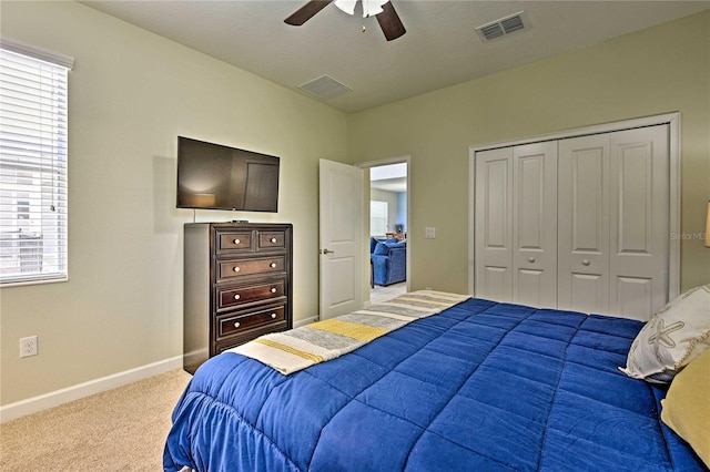 carpeted bedroom featuring multiple windows, a closet, and ceiling fan