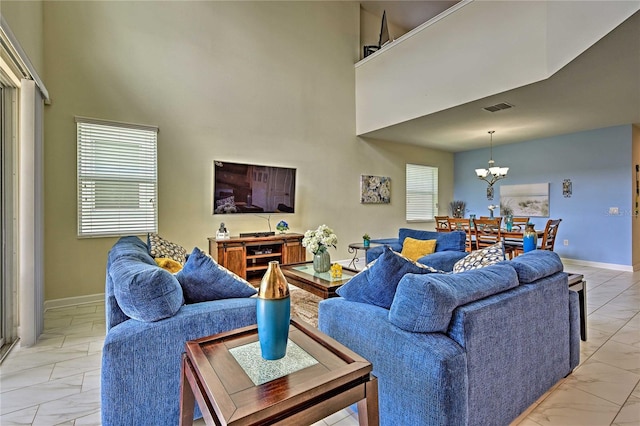 living room with a towering ceiling and a notable chandelier