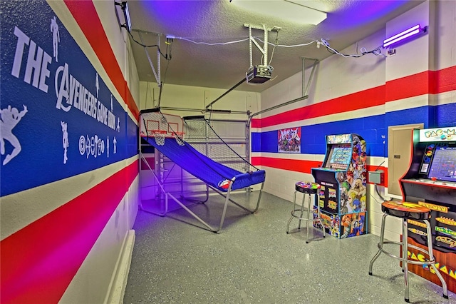 recreation room with a textured ceiling