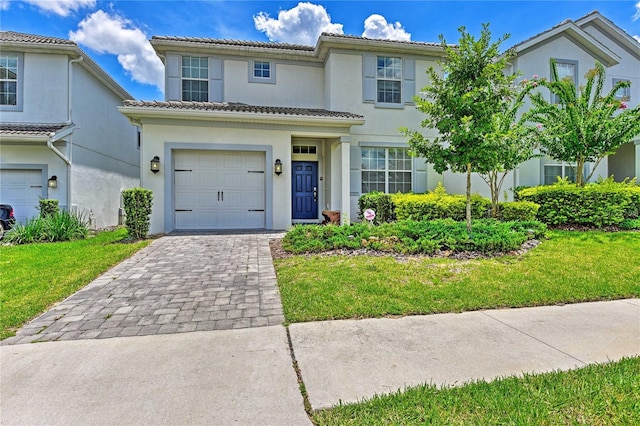 1636 Moon Valley Dr, Davenport, FL 33896 - view of front of house featuring stucco siding, a garage, decorative driveway, and a front yard