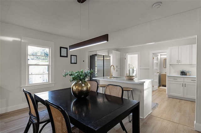 dining room with sink and light hardwood / wood-style floors