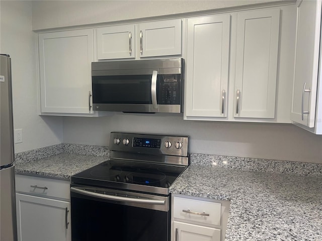 kitchen featuring light stone countertops, white cabinetry, and stainless steel appliances