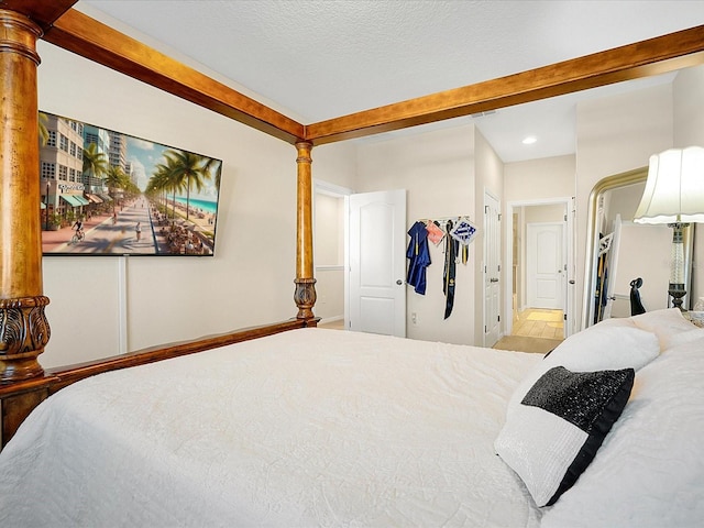 bedroom featuring ensuite bathroom and decorative columns