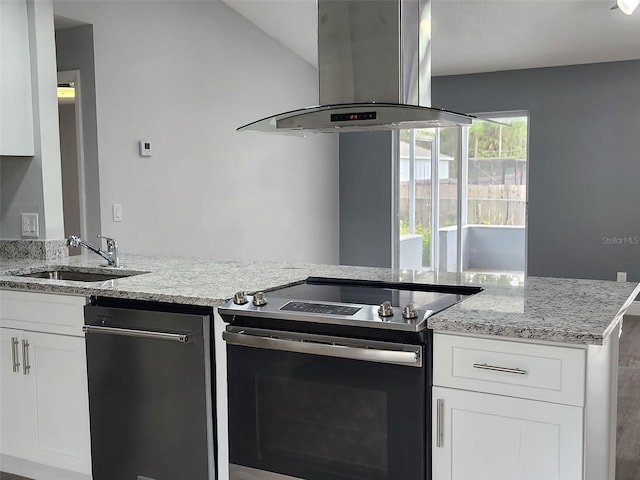 kitchen featuring light stone countertops, stainless steel electric range oven, island range hood, white cabinets, and a sink