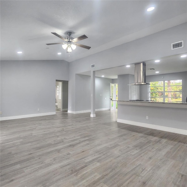 unfurnished living room featuring visible vents, baseboards, lofted ceiling, wood finished floors, and a ceiling fan