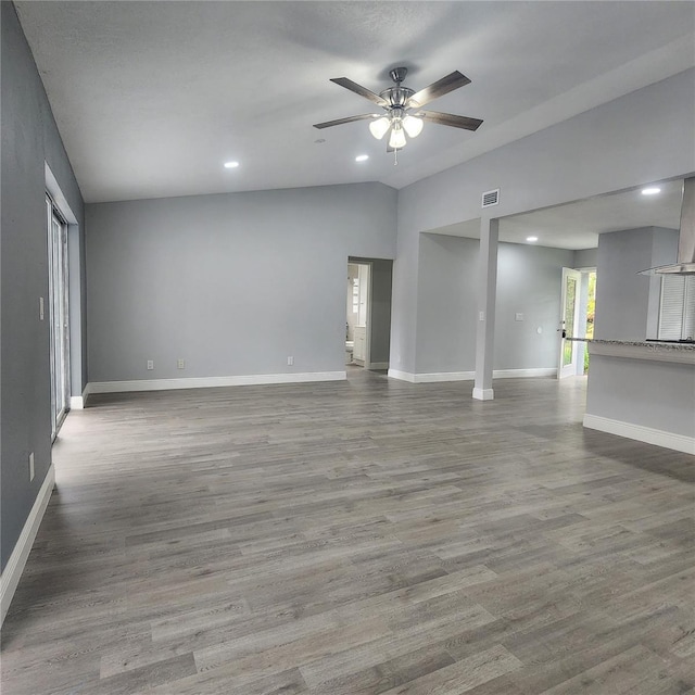 interior space with visible vents, lofted ceiling, baseboards, and wood finished floors