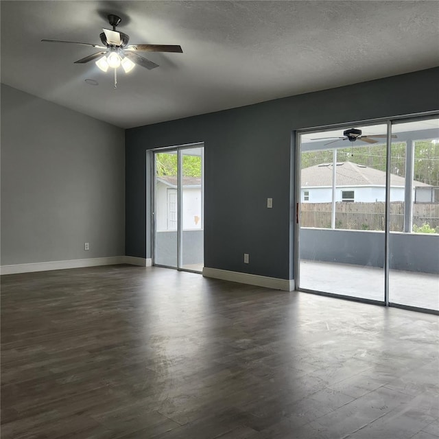 unfurnished room with a textured ceiling, dark wood finished floors, baseboards, and ceiling fan