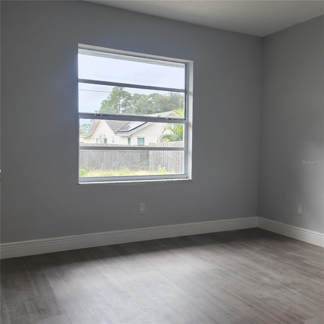 spare room featuring wood finished floors and baseboards