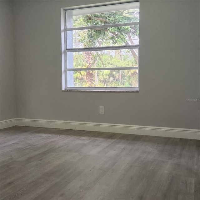 unfurnished room featuring baseboards and wood finished floors