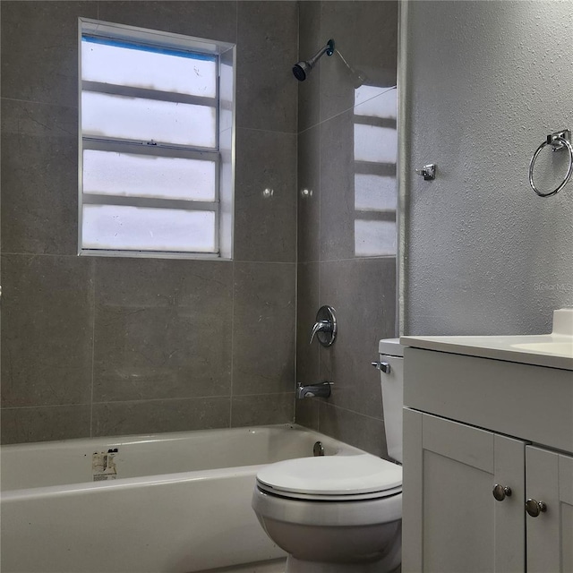 full bath with shower / tub combination, a healthy amount of sunlight, toilet, and vanity