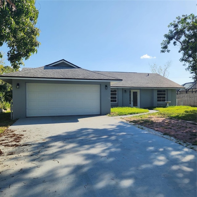 single story home featuring concrete driveway, an attached garage, and stucco siding