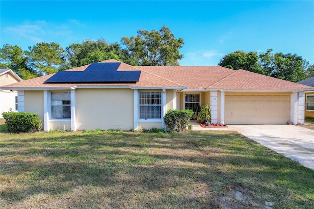 ranch-style house with solar panels, a garage, and a front lawn