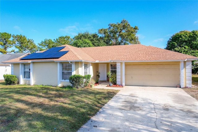 ranch-style home featuring solar panels, a garage, and a front lawn